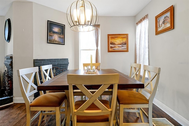 dining area featuring a notable chandelier, wood finished floors, and baseboards