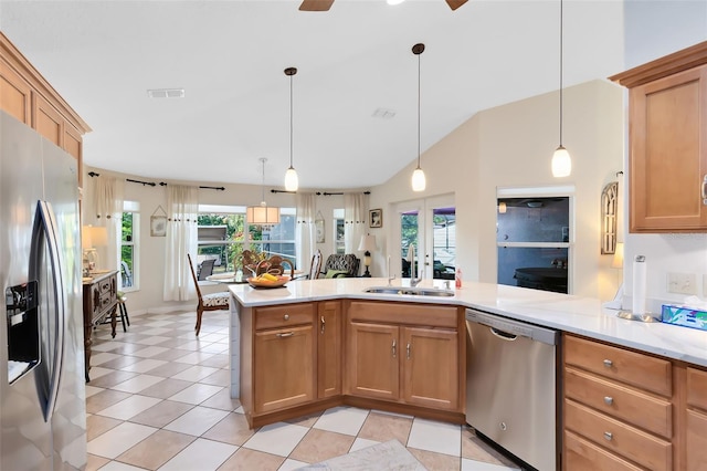 kitchen with sink, hanging light fixtures, kitchen peninsula, stainless steel appliances, and french doors