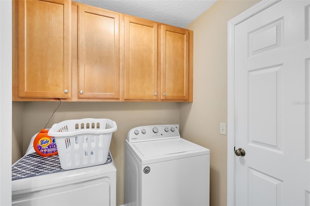 laundry room featuring cabinets, washing machine and dryer, and a textured ceiling