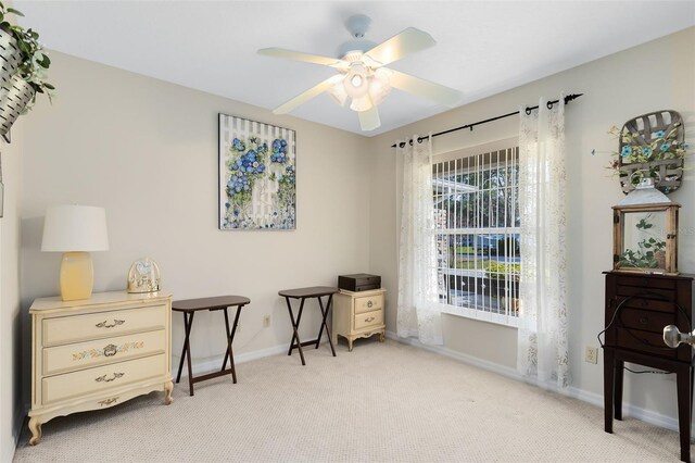 sitting room with ceiling fan and light colored carpet