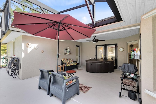 view of patio / terrace featuring ceiling fan, a lanai, and a hot tub