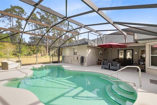 view of pool featuring a jacuzzi, a patio area, and glass enclosure