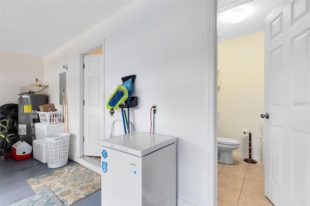 laundry area with electric water heater, light tile patterned floors, and electric panel