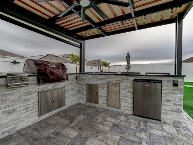 view of patio featuring ceiling fan, grilling area, and exterior kitchen