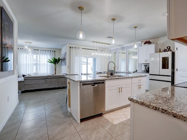 kitchen with sink, fridge, stainless steel dishwasher, pendant lighting, and white cabinets