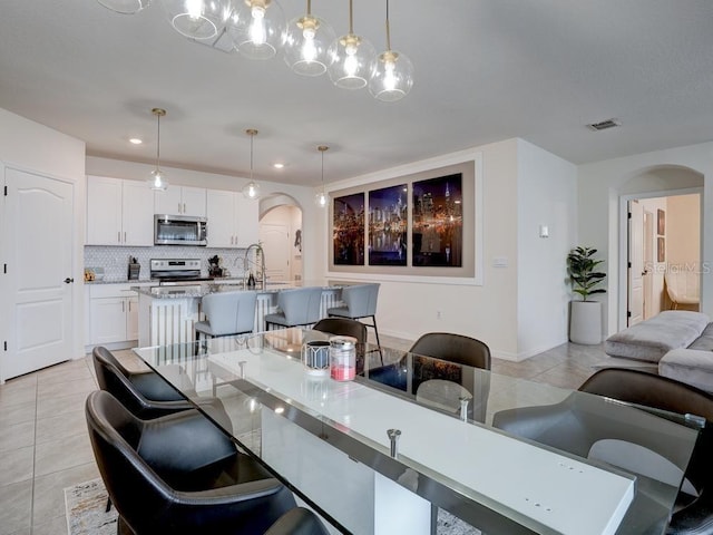 dining space featuring light tile patterned flooring and sink