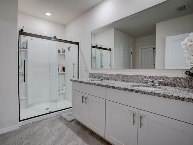 bathroom featuring vanity, a shower with shower door, and tile patterned flooring