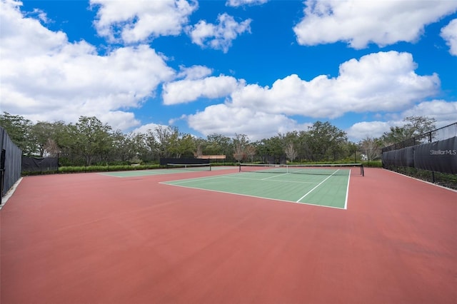 view of tennis court featuring basketball hoop