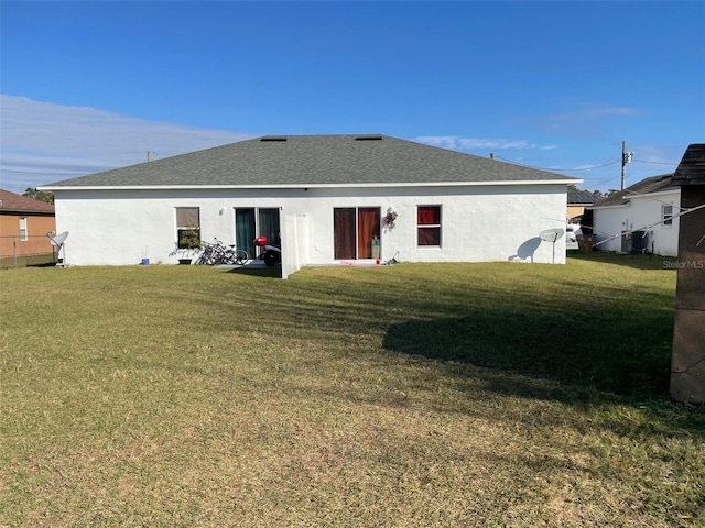 rear view of house featuring a yard