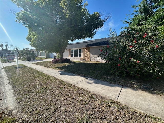 view of front of home featuring concrete driveway and a front lawn