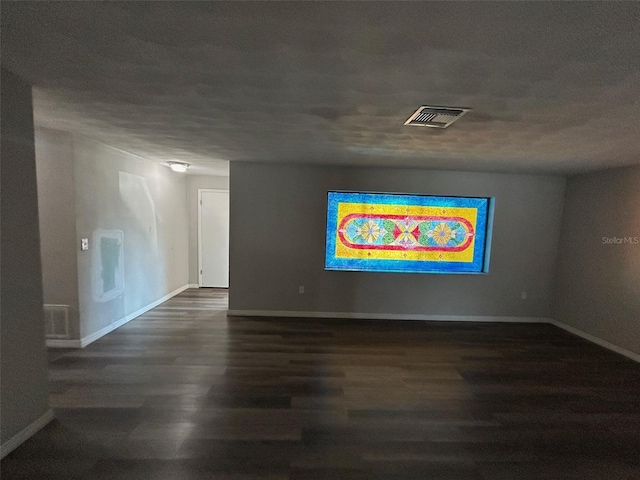 empty room with visible vents, baseboards, and wood finished floors