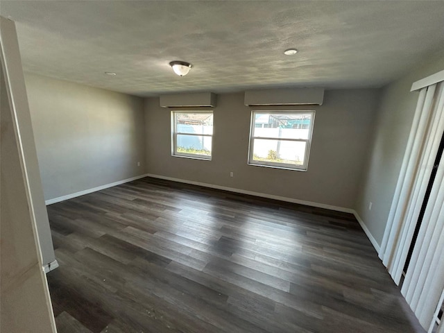 unfurnished room featuring dark wood-style floors and baseboards