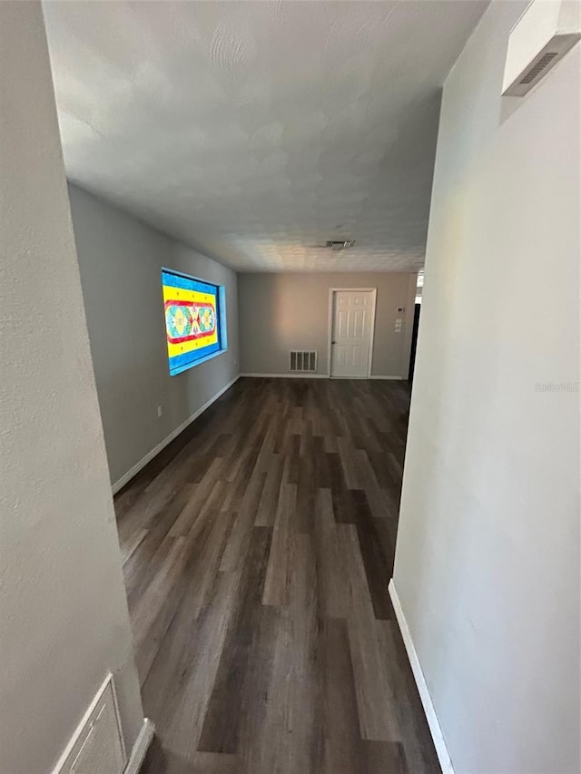 empty room with visible vents, baseboards, and wood finished floors