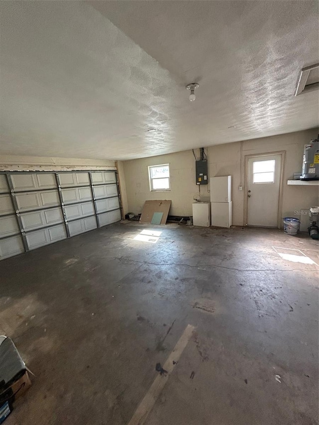 garage with electric panel and freestanding refrigerator