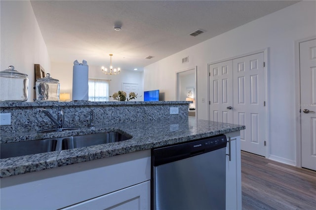 kitchen featuring sink, hanging light fixtures, a notable chandelier, wood-type flooring, and stainless steel dishwasher