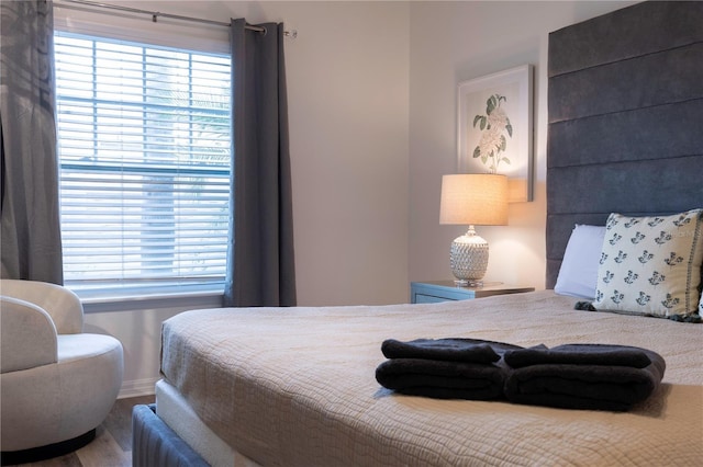 bedroom with wood-type flooring and multiple windows