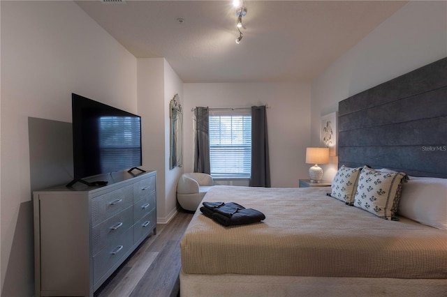 bedroom featuring track lighting and wood-type flooring