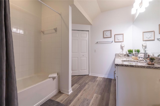 bathroom featuring vanity, hardwood / wood-style floors, vaulted ceiling, and shower / bath combo with shower curtain