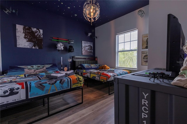 bedroom with an inviting chandelier and hardwood / wood-style floors