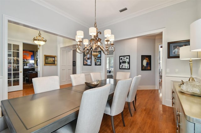 dining room with hardwood / wood-style flooring and crown molding