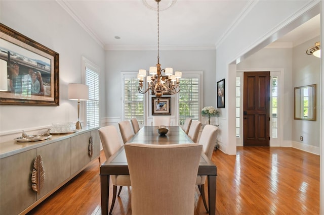 dining space featuring crown molding, a chandelier, light hardwood / wood-style floors, and a wealth of natural light