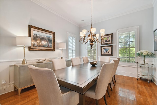 dining area with a notable chandelier, crown molding, and hardwood / wood-style flooring