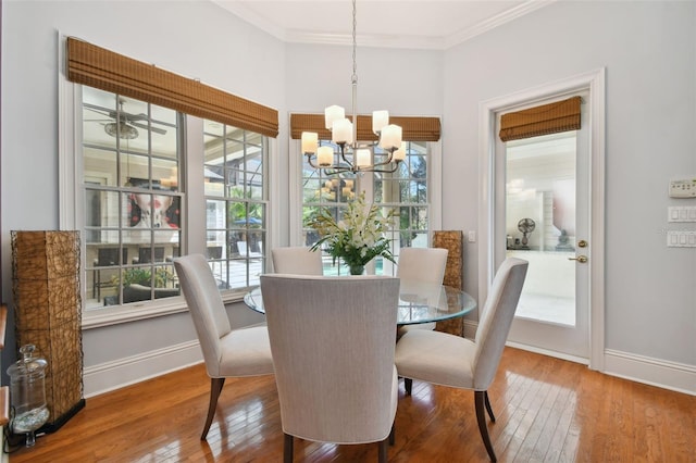 dining space with wood-type flooring, a notable chandelier, and crown molding