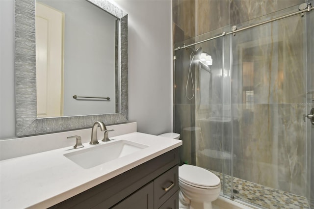 bathroom featuring vanity, toilet, and a shower with shower door