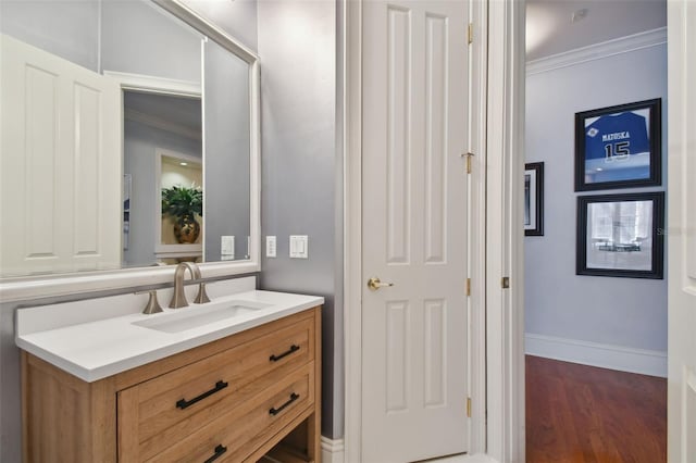 bathroom with hardwood / wood-style flooring, ornamental molding, and vanity