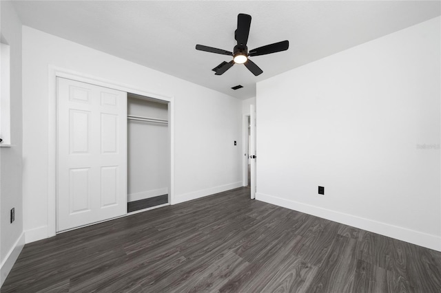 unfurnished bedroom with dark hardwood / wood-style flooring, a closet, and ceiling fan