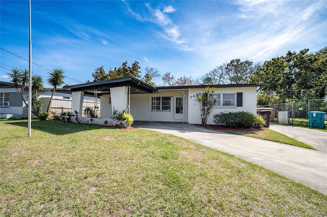 view of front of home with driveway, fence, and a front lawn