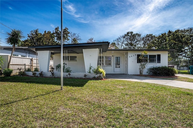 view of front of home with brick siding, a front yard, and fence