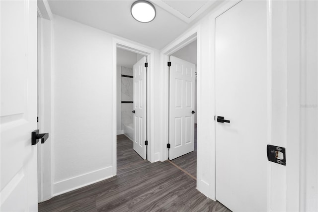 corridor featuring dark wood-style floors and baseboards