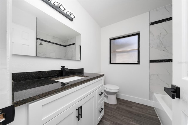 bathroom featuring baseboards, toilet, wood finished floors,  shower combination, and vanity