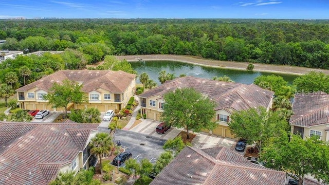 bird's eye view featuring a wooded view, a water view, and a residential view