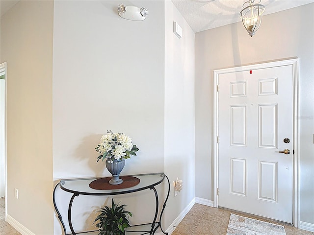 foyer entrance featuring baseboards and light tile patterned flooring