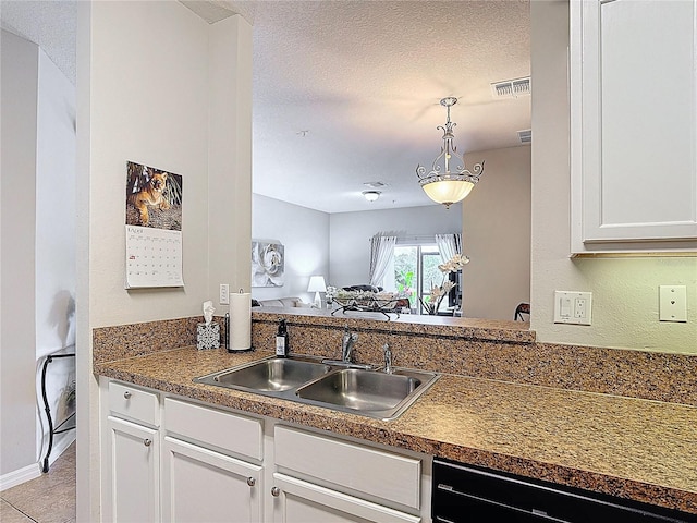 kitchen featuring a sink, dishwashing machine, dark countertops, visible vents, and white cabinets