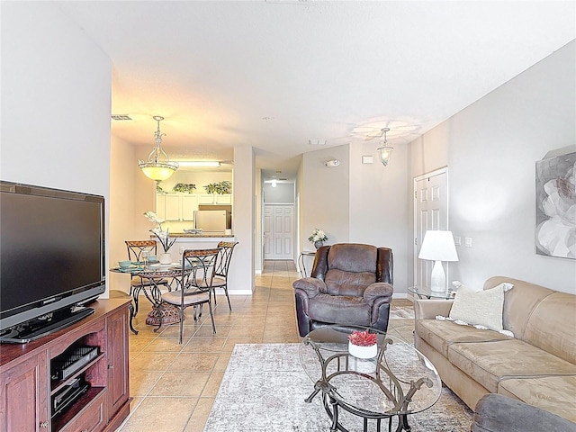 living room with light tile patterned floors, baseboards, and visible vents