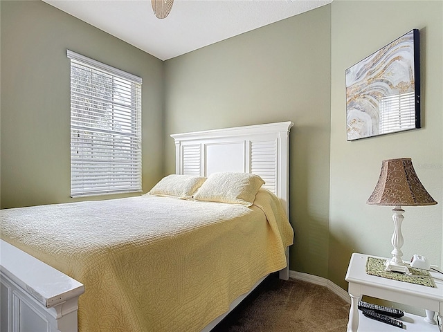 bedroom featuring baseboards and dark colored carpet