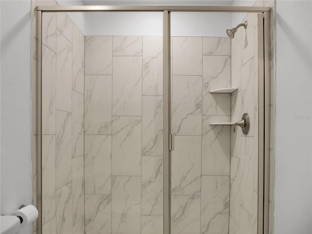 bathroom featuring toilet and a shower with shower door