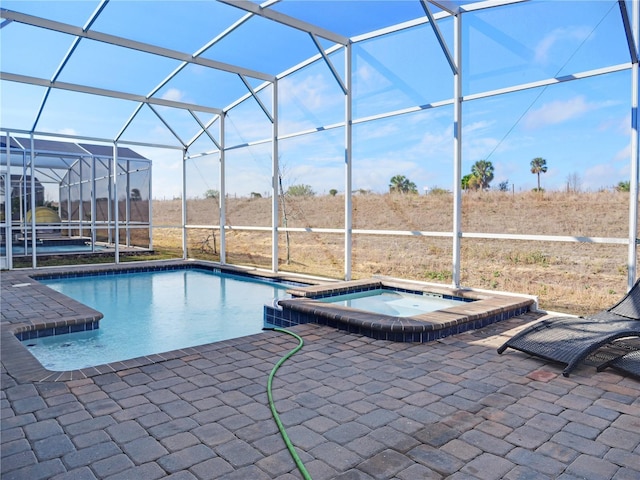 view of swimming pool featuring a lanai, a patio, and an in ground hot tub