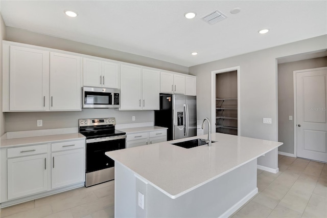 kitchen featuring a kitchen island with sink, sink, white cabinets, and appliances with stainless steel finishes