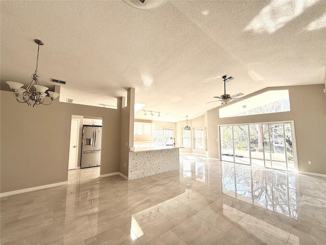 unfurnished living room with lofted ceiling, ceiling fan with notable chandelier, and a textured ceiling