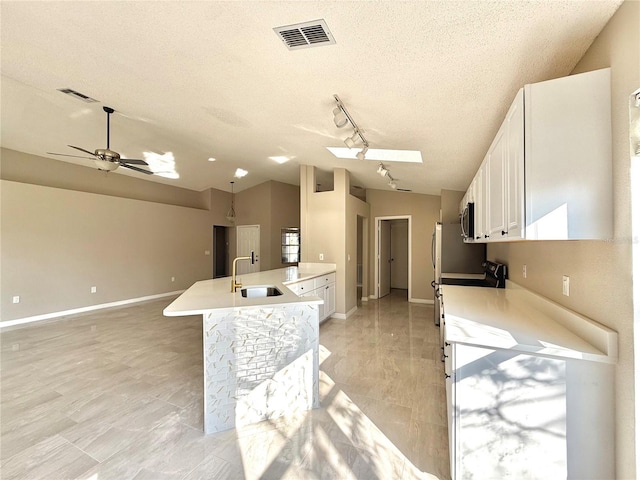 kitchen featuring white cabinetry, sink, electric range, and vaulted ceiling with skylight