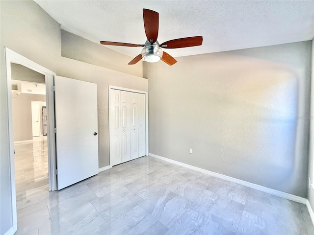 unfurnished bedroom with ceiling fan, a textured ceiling, and a closet