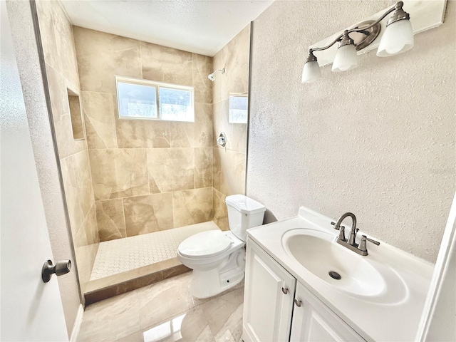 bathroom with vanity, a textured ceiling, toilet, and tiled shower