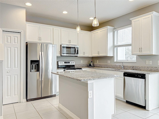 kitchen with light tile patterned floors, stainless steel appliances, a sink, and white cabinets