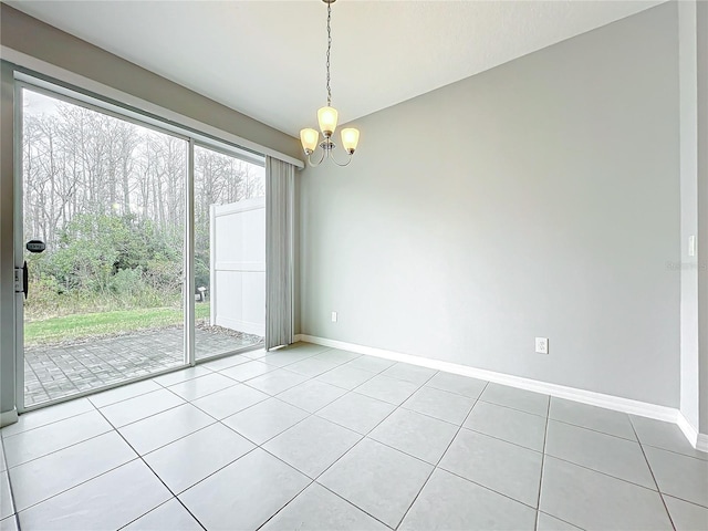 unfurnished room with an inviting chandelier, light tile patterned floors, and baseboards