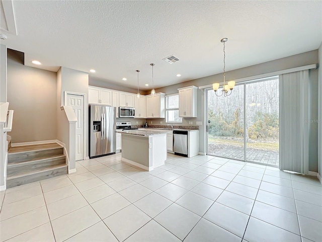 kitchen featuring stainless steel appliances, visible vents, white cabinetry, and light tile patterned floors