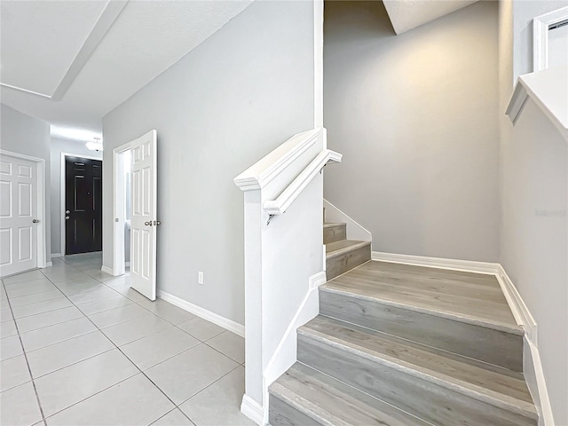 stairway featuring tile patterned flooring and baseboards